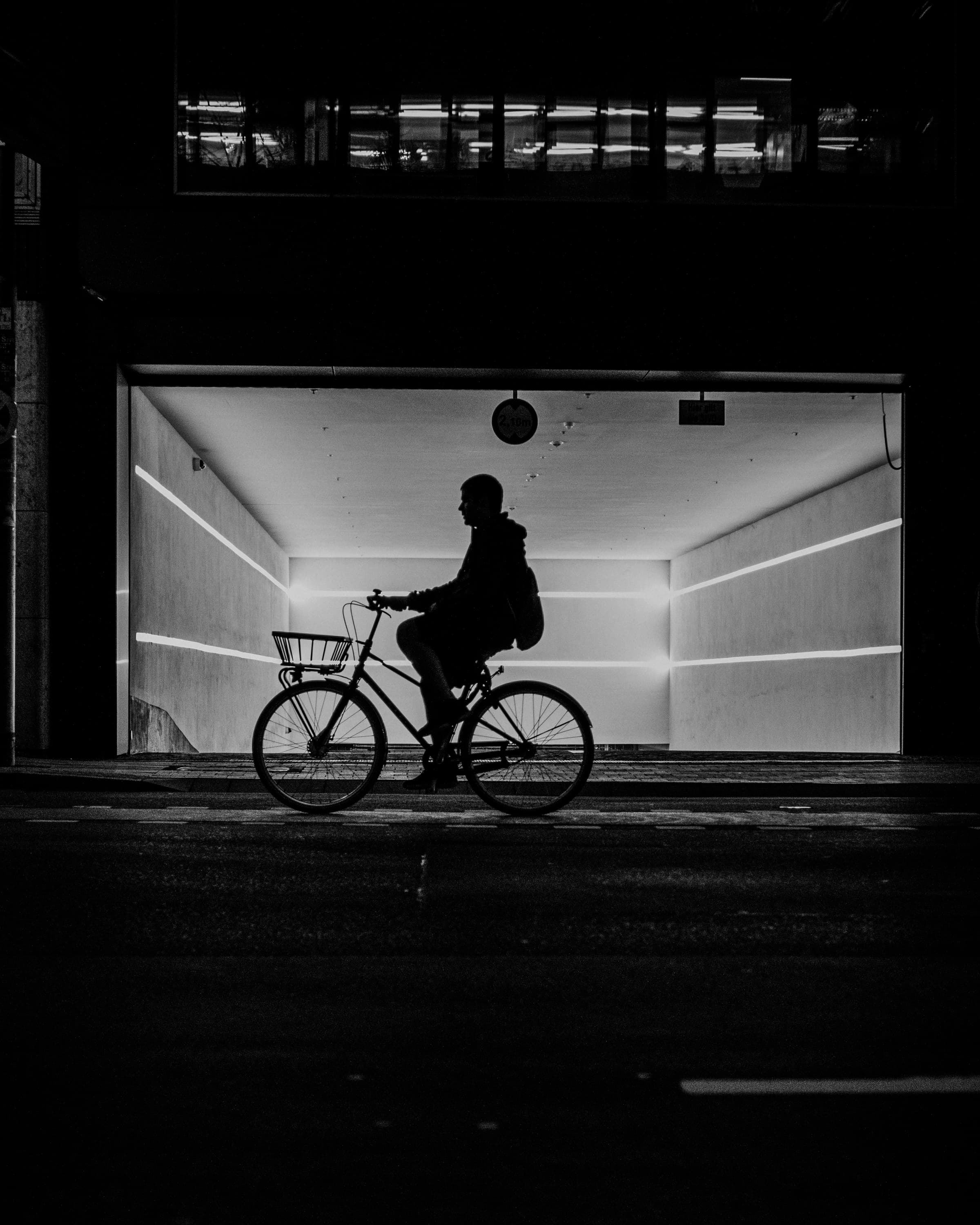 Cyclist in front of a lit passage - before the light.