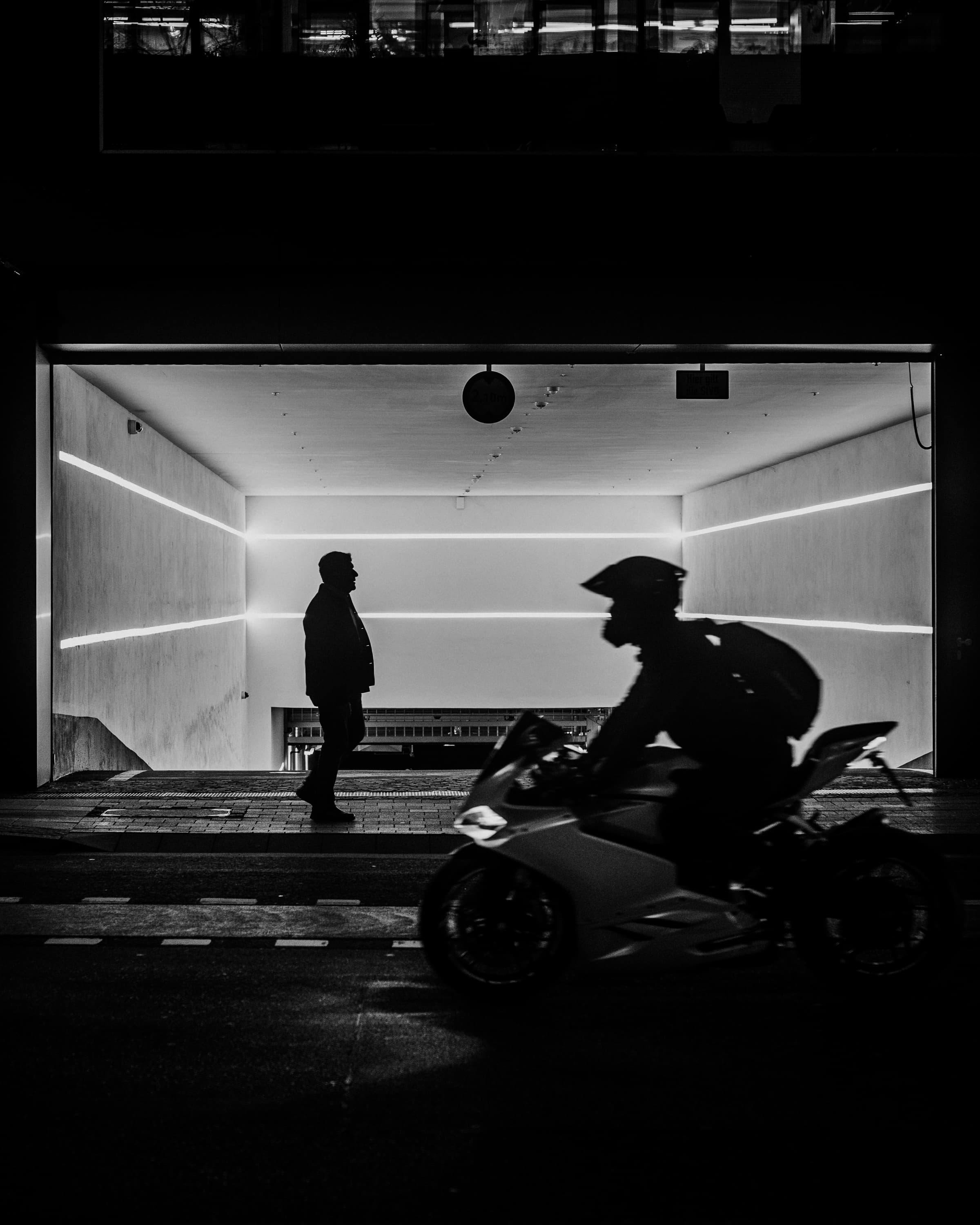 Motorbike in front of a waiting figure - passing through.