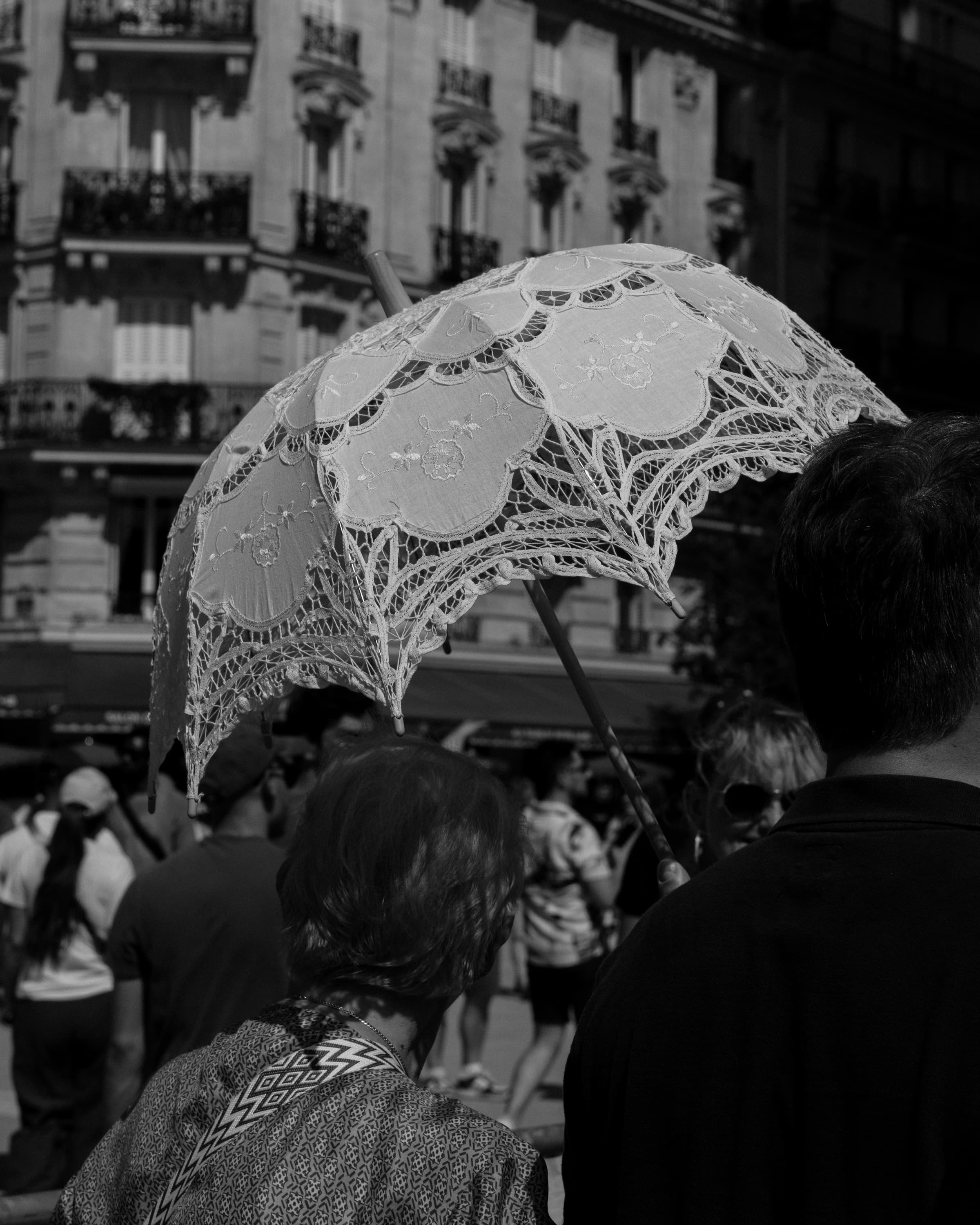 Lace umbrella in the crowd - through the crowd.